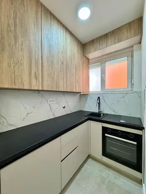 a kitchen with wooden cabinets and a black counter top at Apartman 21 Lux in Banja Luka