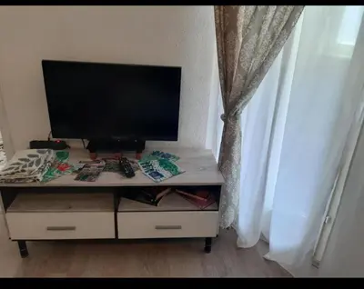 a tv sitting on top of a table in front of a window at Apartman NAFO in Bihać