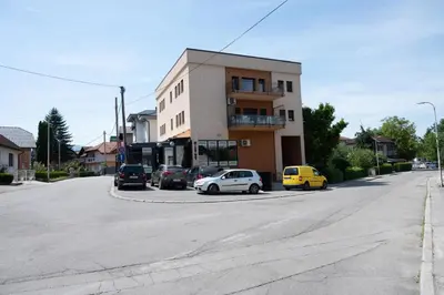 a building with cars parked on the side of a street at Milky Way in Bihać