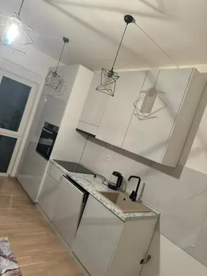 a white kitchen with a sink and some lights at Stan Tešanj in Tešanj