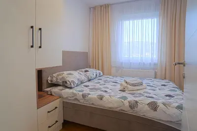 a small bedroom with a bed and a window at Hedonist Garden Luxury Apartments in Doboj