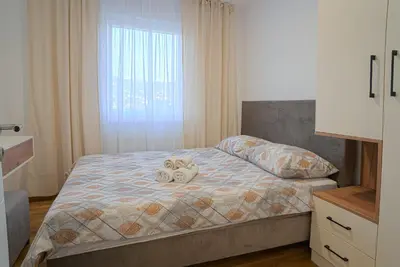 a bedroom with a bed with two stuffed animals on it at Hedonist Garden Luxury Apartments in Doboj