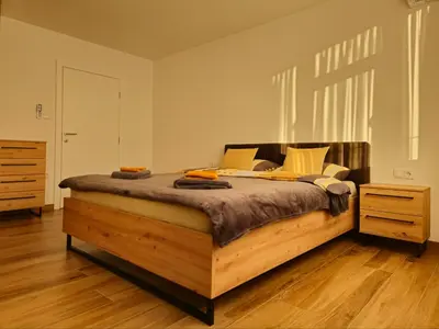 a bedroom with a large wooden bed in a room at Apartman Trg 892 in Livno