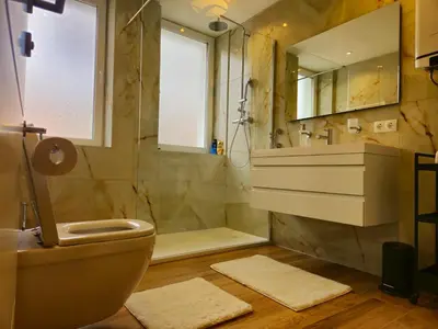 a bathroom with a shower and a toilet and a sink at Apartman Trg 892 in Livno