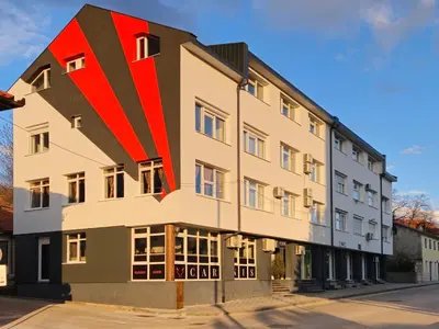 a building with a red stripe on the side of it at Apartman Trg 892 in Livno