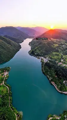 an aerial view of a river with the sun setting at Cottage MIRNI RAJ in Jajce