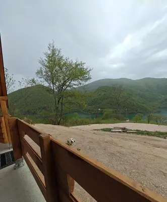 a wooden fence with a view of a mountain at Cottage MIRNI RAJ in Jajce