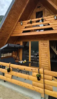 a log cabin with a deck and a patio at Cottage MIRNI RAJ in Jajce
