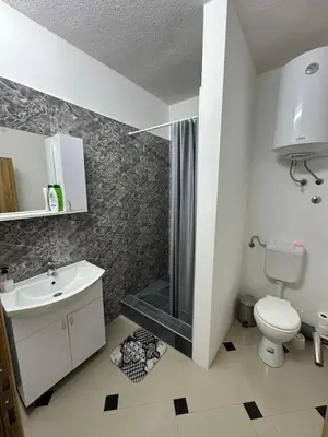a bathroom with a shower and a toilet and a sink at Apartmani Orhideja za 2 osobe studio in Sanski most