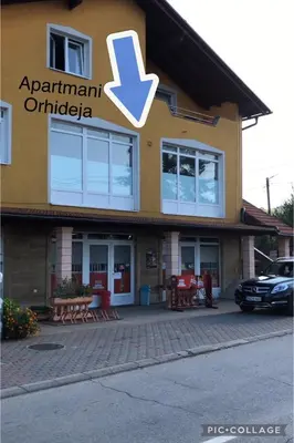 a building with an arrow sign on the side of it at Apartmani Orhideja za 2 osobe studio in Sanski most