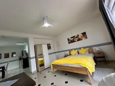 a bedroom with a bed with a yellow blanket at Apartmani Orhideja za 2 osobe studio in Sanski most