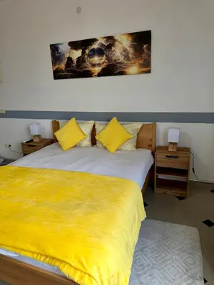 a bedroom with two beds with a yellow blanket at Apartmani Orhideja za 2 osobe studio in Sanski most