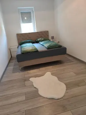 a bedroom with a bed and a rug on the floor at Sokak Apartman in Bihać