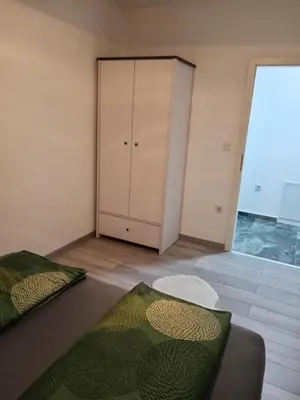 a bedroom with a bed and a cabinet in it at Sokak Apartman in Bihać