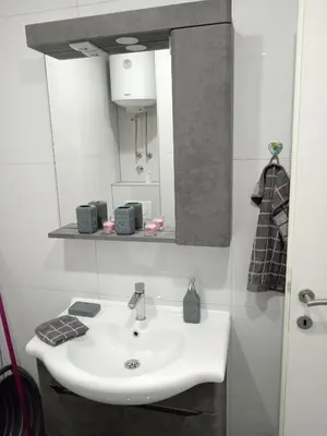 a bathroom with a white sink and a mirror at Sokak Apartman in Bihać