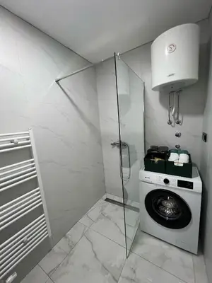 a bathroom with a washing machine and a shower at Max stan na dan Doboj in Doboj