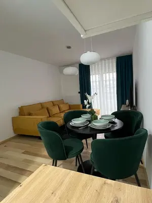 a living room with a table and green chairs at Max stan na dan Doboj in Doboj