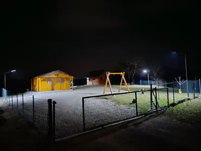 a playground at night with a yellow swing at Vikendica Ajlin in Spahići