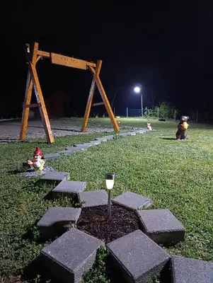 a stone walkway with a wine glass in the grass at Vikendica Ajlin in Spahići