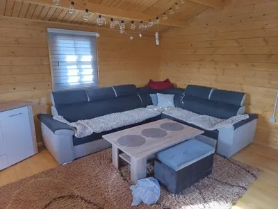 a living room with a blue couch and a table at Vikendica Ajlin in Spahići