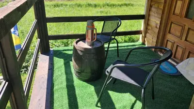 a table and a chair and a wine bottle on a barrel at Dream House Šeha in Bihać