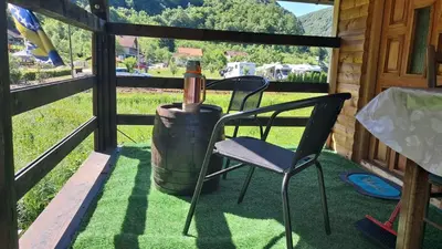 a wine bottle sitting on a chair next to a barrel at Dream House Šeha in Bihać