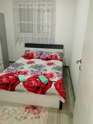a bedroom with a bed with red roses on it at Apartman Oaza mira-Visoko in Visoko