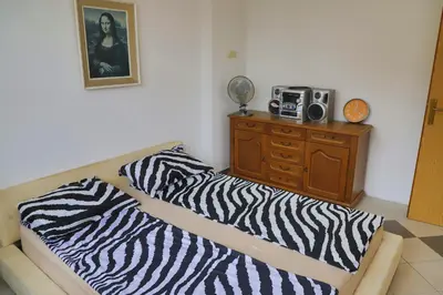 a room with two beds and a dresser with a radio at Apartman MIŠKO in Bihać