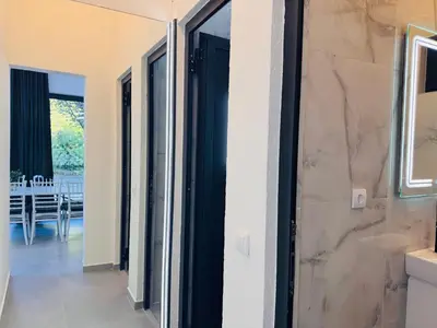 a hallway with doors leading to a dining room at Villa Happiness in Banja Luka
