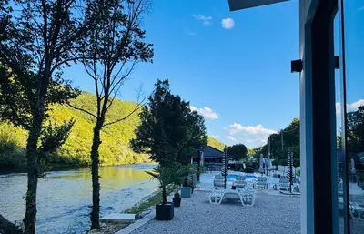 a view of a river with white benches and trees at Villa Happiness in Banja Luka