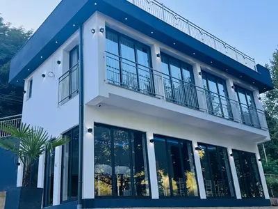 a house with a blue roof and windows at Villa Happiness in Banja Luka