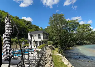 a house with a swimming pool next to a river at Villa Happiness in Banja Luka