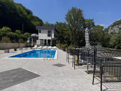 a swimming pool with chairs and a house at Villa Happiness in Banja Luka