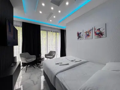 a bedroom with a bed and a desk and a window at Villa Happiness in Banja Luka