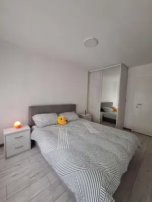 a bedroom with a large bed with a yellow pillow on it at Cosy Corner Doboj in Doboj