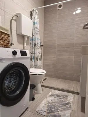 a bathroom with a washing machine and a toilet at Cosy Corner Doboj in Doboj