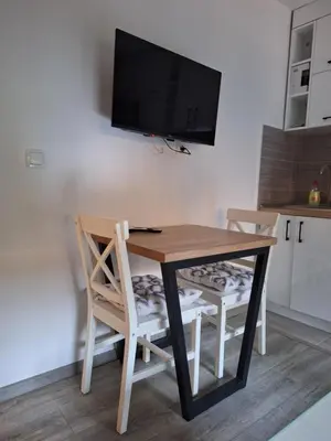 a table with two chairs and a television on a wall at Cosy Corner Doboj in Doboj