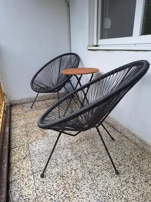 a black chair and a table sitting next to a window at Cosy Corner Doboj in Doboj