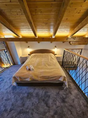 a large bed in a room with a wooden ceiling at Luxury Villa Mašić - 2 in Bugojno