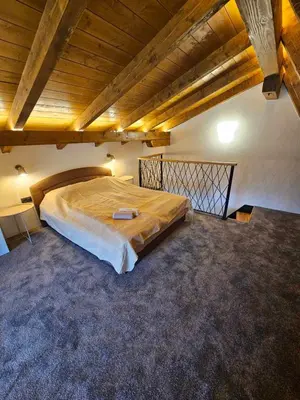 a large bed in a room with a wooden ceiling at Luxury Villa Mašić - 2 in Bugojno