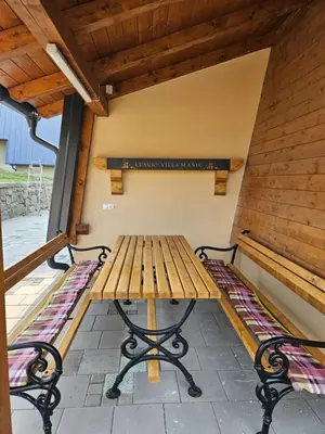 a wooden table and benches on a patio at Luxury Villa Mašić - 2 in Bugojno