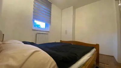 a bedroom with a bed and a window with a blind at Apartment 3A Visoko in Visoko