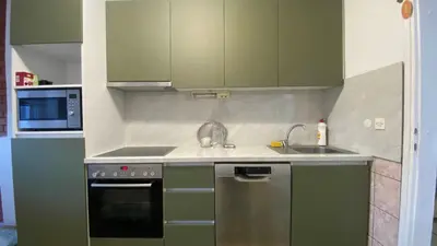 a kitchen with green cabinets and a sink and a stove at Apartment 3A Visoko in Visoko
