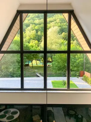 a room with a large window looking out at a garden at Unea House in Bihać