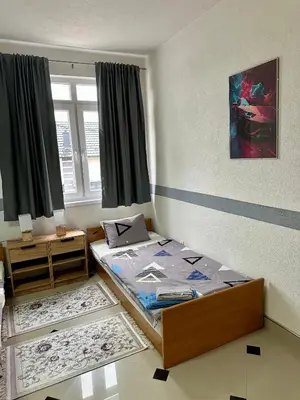 a small bedroom with a bed and a window at Apartmani Orhideja za 4 osobe in Sanski most