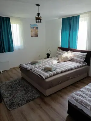 a large bed in a room with blue curtains at Oaza mira Šipovo in Šipovo