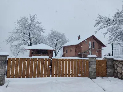 a house with a wooden fence in the snow at Oaza mira Šipovo in Šipovo