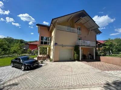 a black car parked in front of a house at Apartmani D&D 4 in Jajce