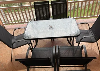 a table and chairs on a balcony with a table and chairs at Apartmani D&D 4 in Jajce