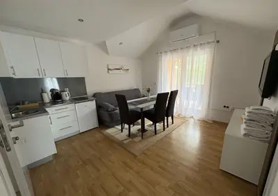 a kitchen and dining room with a table and chairs at Apartmani D&D 4 in Jajce